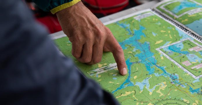 ken whiting pointing to a map of the rideau canal lock passage fishing in ontario paddle tales paddletv