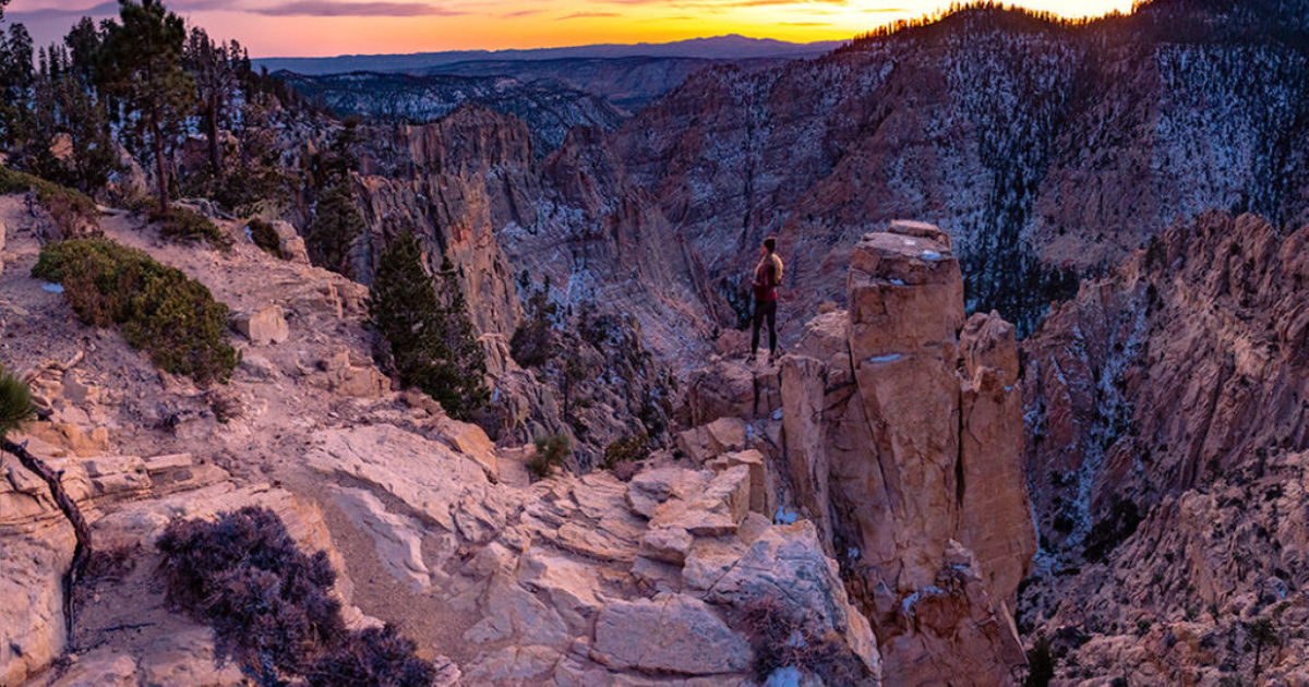 kristi overlooking the landscape with the sun setting backpacking and hiking