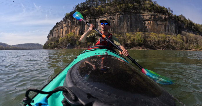 ken whiting kayaking in a pakayak portable kayak with nrs pfd wiley x sunglasses and an aqua bound paddle