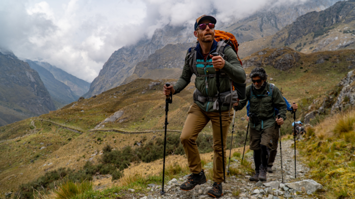 how to go on an international trek featured image group of backpackers climbing high altitudes in peru