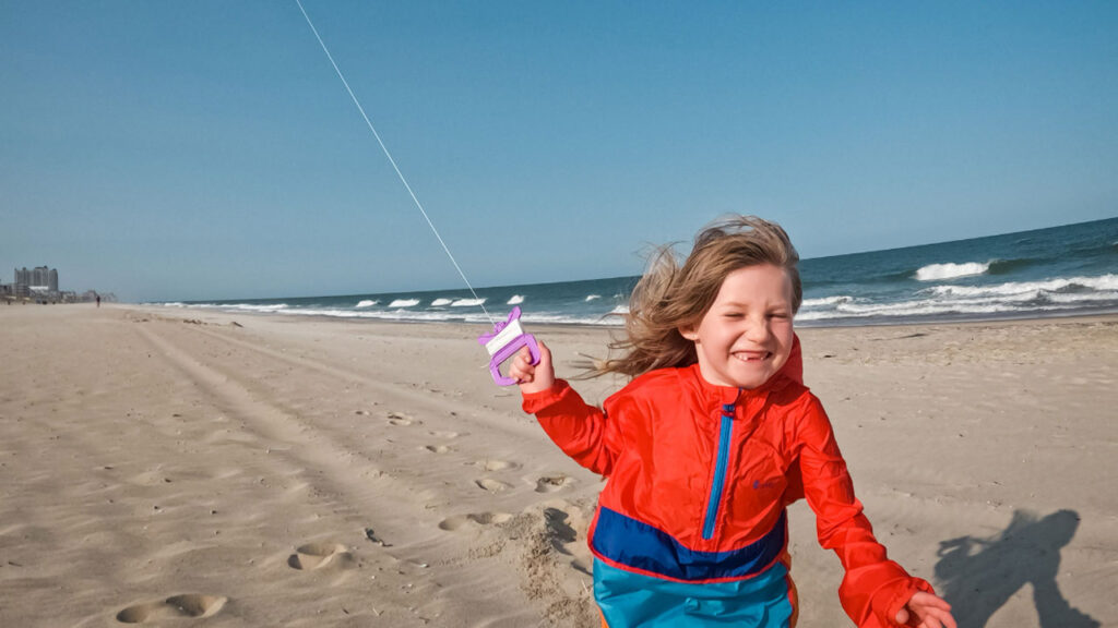 Kite flying on the beach instantly became a favorite.  Check out that grin!