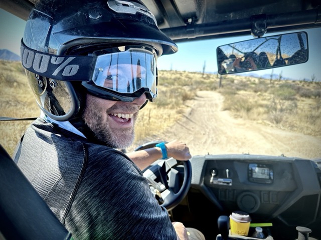 Jonathan Thompson, smiling at the camera from the drivers seat of an ATV on a trail, Scottsdale, Arizona