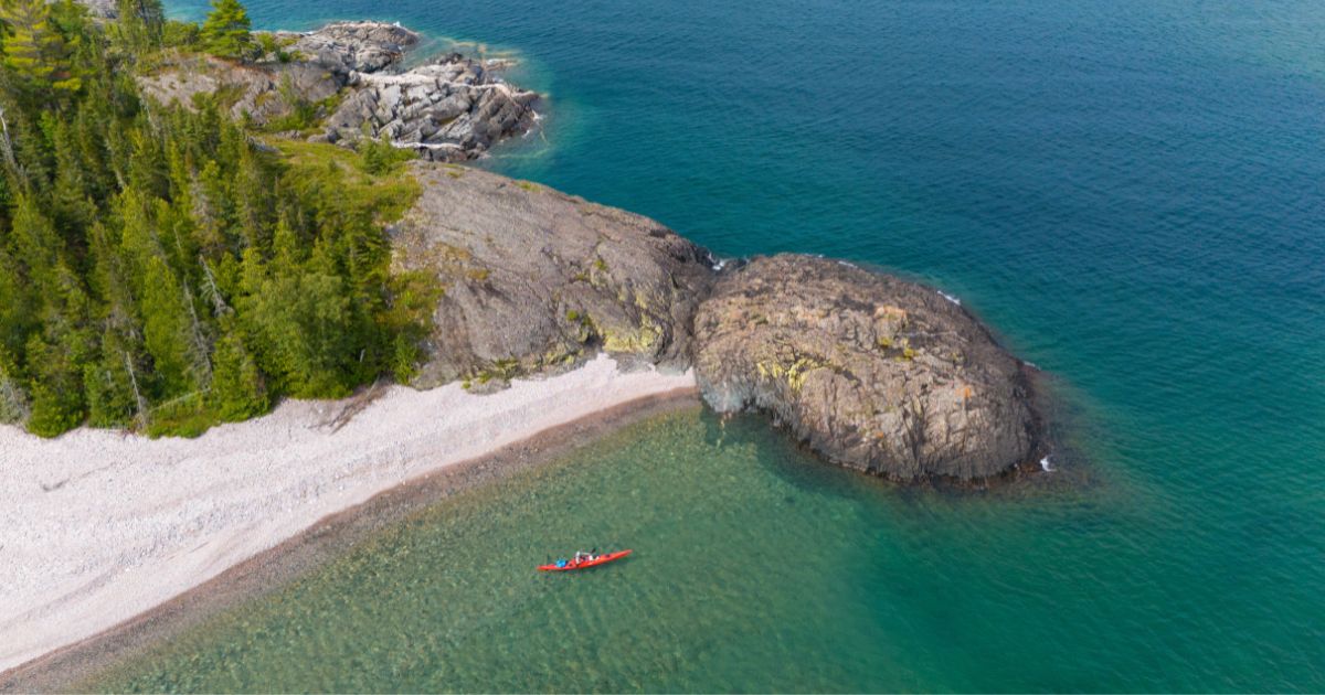 A dramatic view of Lake Superior's rocky cliffs and crystal-clear water, a highlight of kayak camping adventures.