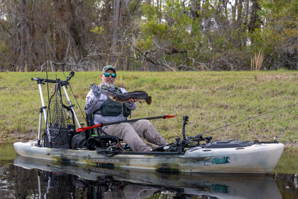 Kayak Fishing Okefenokee swap fishing with Chris funk sitting in boat holding caught fish