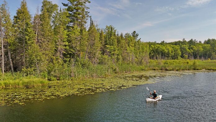 Shows the type of flatwater environment that the Lake Sport kayak is suited for.